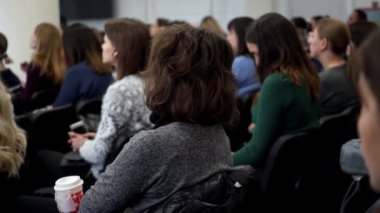 Dinleyici kitlesi sunumu. Konferans salonunda oturan bayan dinleyiciler. Kadın koç konferansta konuşma yaptı.