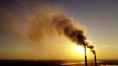 Gün batımında hava kirliliği. Kirli dumanlı endüstriyel borular atmosferi kirletiyor. Akşamları zehirli dumanlı iki büyük boru..