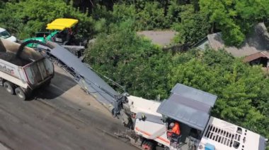 Yeni asfalt yolun inşaatı. Yazın yoldaki karavana asfalt yerleştiren özel ekipmanlar. Üst görünüm.