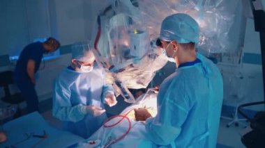 Modern klinikte işletim süreci. Mikroskopla hastaya ameliyat yapan cerrahların takım çalışması. Tıptaki çağdaş teknolojiler.