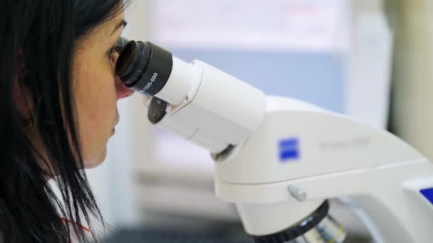 Γυναίκα Μελετάει Δείγματα Από Μικροσκόπιο Νεαρός Εργαστηριακός Εργάτης Κάνει Διάγνωση — Αρχείο Βίντεο