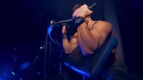 运动员抽吸他的胳膊二头肌 肌肉男运动员在体育中心的现代设备上做艰苦的锻炼 — 图库视频影像