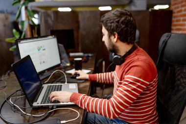 Ofiste çalışan yakışıklı genç bir programcı. Programlama ve kodlama teknolojileri geliştiriliyor.