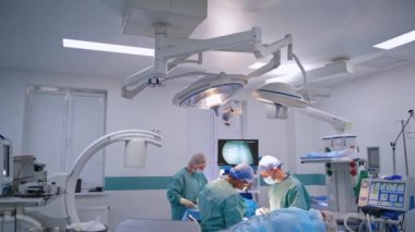 Ameliyathanede iki cerrah ve asistan var. Klinikteki modern ekipmanlar ve ileri doktorlar klinikte bir ameliyat gerçekleştirdiler..