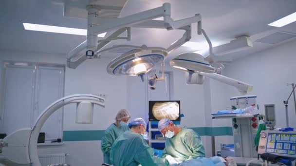 Modern Ameliyathanede Cerrahların Takım Çalışması Klinikteki Çağdaş Ekipmanlar Tıbbi Üniformalı — Stok video