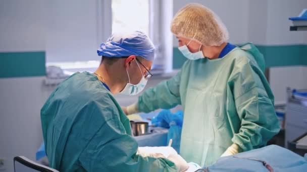 Cerrah Asistan Ameliyat Yapıyor Modern Bir Ameliyathanede Koruyucu Giysi Konusunda — Stok video