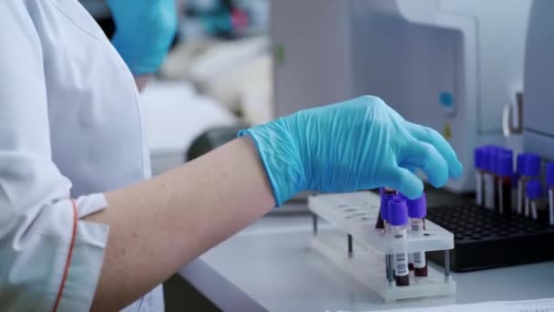 Laboratoriummedewerker Met Bloedmonsters Vrouwenhanden Steriele Handschoenen Met Reageerbuisjes Tafel Het — Stockvideo