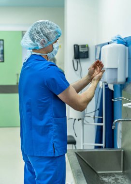 Doktor ellerini yıkıyor. Cerrah ameliyattan önce ellerini yıkıyor.