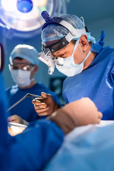 Team surgeon at work in operating room. Modern equipment in operating room. Medical devices for neurosurgery.