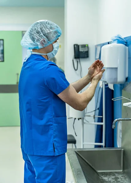 Doktor ellerini yıkıyor. Cerrah ameliyattan önce ellerini yıkıyor.