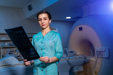 Hastanede tomografi cihazının yanında dururken röntgen teşhisini incelerken çekilen radyoloji görüntüsü..