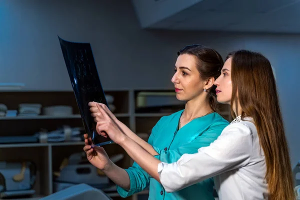 Healthcare, medical and radiology concept - two doctors looking at x-ray.
