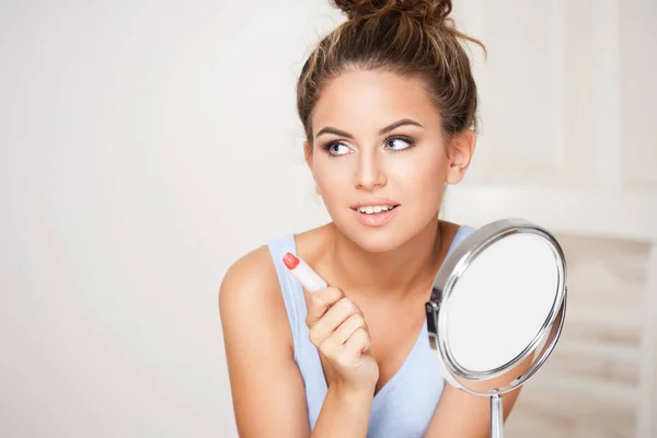 Unga brunett kvinna använder kosmetika. — Stockfoto