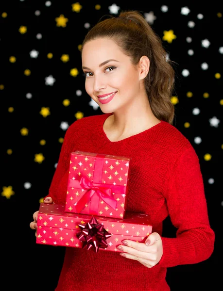 Brunette woman holding Christmas gifts. — Stock Photo, Image