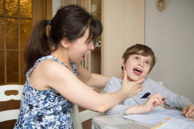 Bir anne kesinlikle birinci sınıftaki oğluyla kavga ediyor. Koronavirüs salgınından dolayı izolasyon görevlerine zorlanıyorlar..