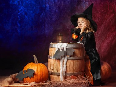 balkabağına içinde oturan bir cadı kostüm dalgın küçük kız bir