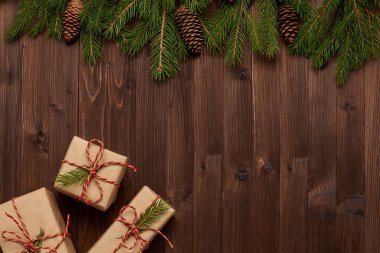 Christmas arrangement of gifts in Kraft paper on brown wooden ba clipart