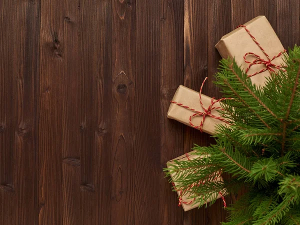 Arreglo de Navidad de regalos en papel Kraft en madera marrón ba — Foto de Stock