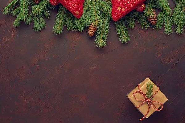 Composición navideña de campanas rojas, ramas de abeto, regalos en kraft — Foto de Stock