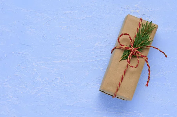 Regalo de Navidad en papel Kraft con lazo rojo beige con cordel y — Foto de Stock