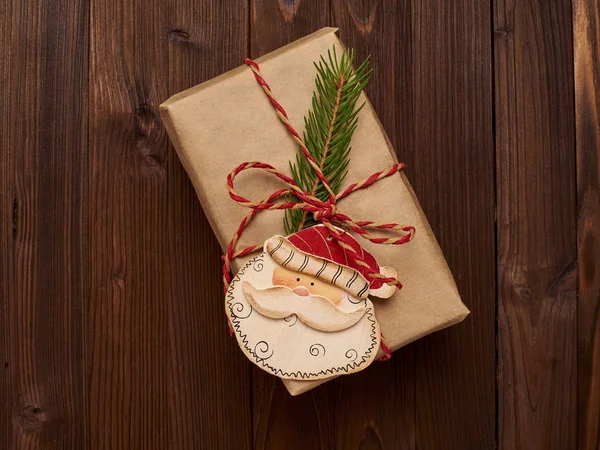 Regalo de Navidad en papel kraft decorado con ramas de abeto y — Foto de Stock