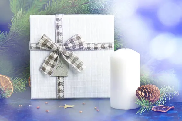 Christmas gift box with checkered ribbon, a candle of dried oran — Stock Photo, Image