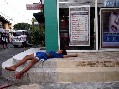 Genç bir çocuk bir dükkanın önünde uyuyor