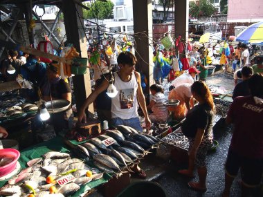 Bir ıslak pazar satıcı genel bir pazarda taze deniz ürünleri çeşitli satıyor.