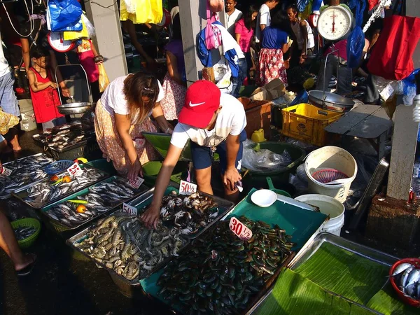 Um vendedor de mercado húmido vende uma variedade de frutos do mar frescos em um mercado público . — Fotografia de Stock