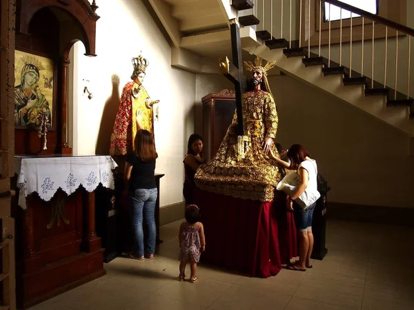 Catholic devotees pray to religious images inside a prayer room at the Antipolo Cathedral. — Stock Photo, Image