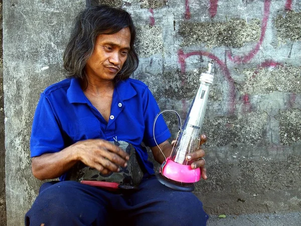 Człowiek tworzy i sprzedaje alkoholu fueled lampy wykonane z materiałów pochodzących z recyklingu. — Zdjęcie stockowe