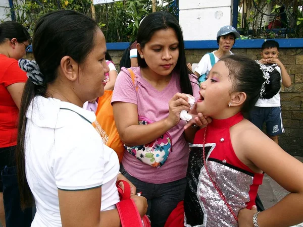 Una madre aplica lápiz labial y maquillaje a su hijo que participa en un desfile durante el Festival de Sumaka en la ciudad de Antipolo . — Foto de Stock