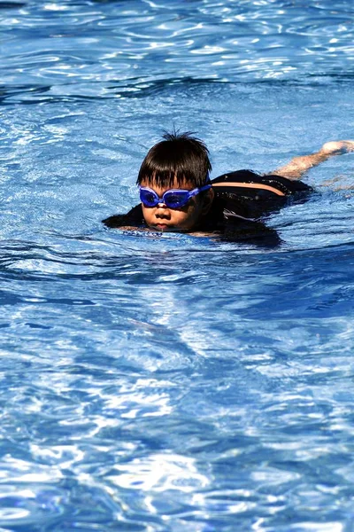 Young boy swimming in a swimming pool. — Stock Photo, Image