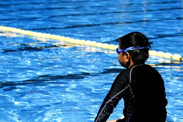 Kid förbereder sig för att bada i en pool. — Stockfoto