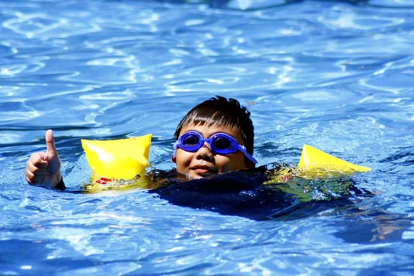 Young kid swimming in a swimming pool. — Stock Photo, Image