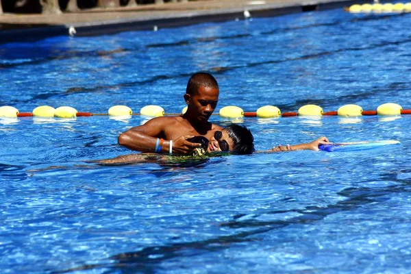 Un niño aprende a nadar con la ayuda de un entrenador de natación . —  Fotos de Stock