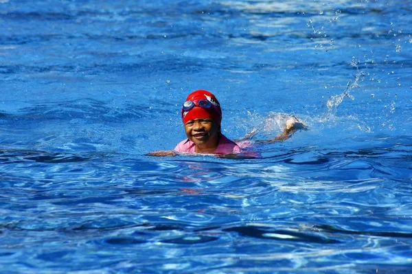 아이 kickboard의 도움으로 수영 하는 방법을 배운다합니다. — 스톡 사진