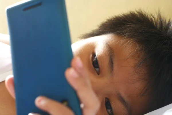 Mladý kluk sledoval na smartphone — Stock fotografie