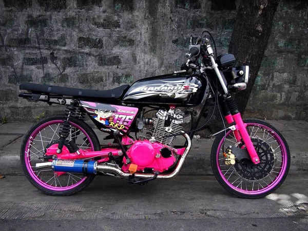 Una colorida motocicleta estacionada a lo largo de una calle . —  Fotos de Stock