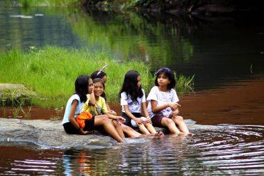 Bir grup çocuk tarafından bir göl kıyısındaki oynamak ve ayaklarını suya ıslak.