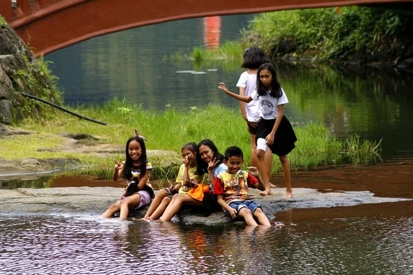 Un gruppo di bambini gioca in riva al lago e hanno i piedi bagnati nell'acqua . — Foto Stock