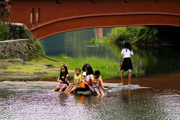 Skupina dětí hrát jezera a mít své nohy mokré ve vodě. — Stock fotografie