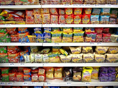 Cips ve diğer ıvır zıvır yiyecekler müşteriler tarafından alınmayı hazır bir bakkal ekranda.