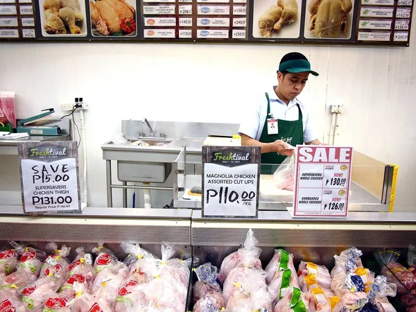 Los trabajadores de una tienda de comestibles cortan carne fresca en una sección de carne de una tienda de comestibles para un cliente . — Foto de Stock