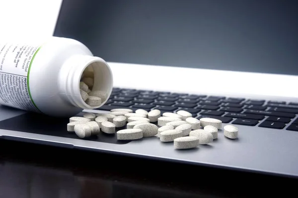Tabletas de medicina en un ordenador portátil . —  Fotos de Stock