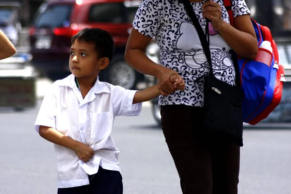 Un jeune étudiant marche avec sa mère pour aller à l'école . — Photo