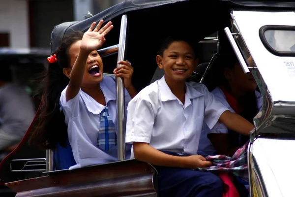 Uczniowie jeździć trójkołowy w drodze do szkoły. — Zdjęcie stockowe