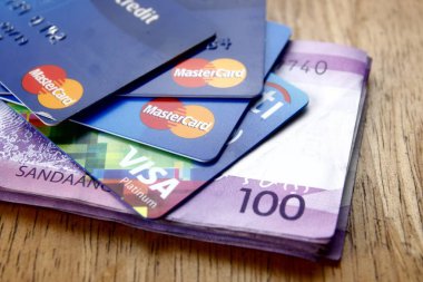 Mastercard ve Visa kredi kartları ve yüz Filipinler Pezosu faturaları bir tablo üzerinde bir demet.
