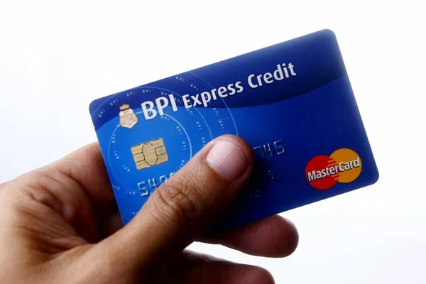 En hand håller en Bpi Express kreditkort Mastercard. — Stockfoto