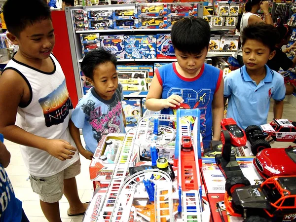 Crianças brincam com brinquedos em uma loja de brinquedos no shopping SM City em Taytay City, Filipinas . — Fotografia de Stock